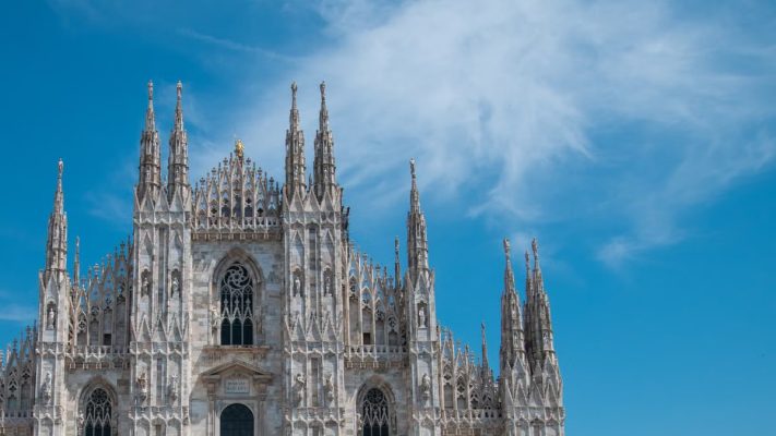 Stunning architectural detail of Milan Cathedral with clear blue skies, showcasing gothic splendor.